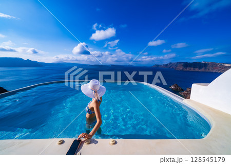 ギリシャのサントリーニ島のプールで泳ぐ女性 128545179