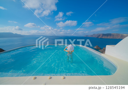 ギリシャのサントリーニ島のプールで泳ぐ女性 128545194