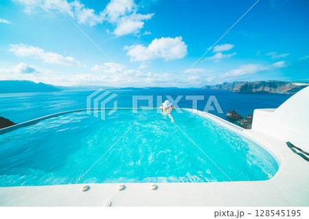ギリシャのサントリーニ島のプールで泳ぐ女性 ギリシャのサントリーニ島のプールで泳ぐ女性 128545195