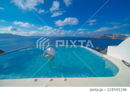 ギリシャのサントリーニ島のプールで泳ぐ女性 128545196