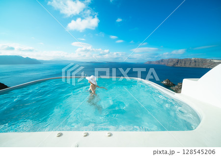 ギリシャのサントリーニ島のプールで泳ぐ女性 128545206
