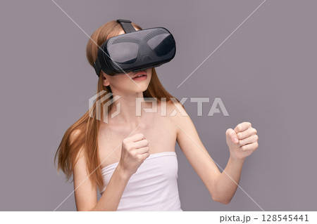Young caucasian female experiencing virtual reality with vr headset, engaged 128545441