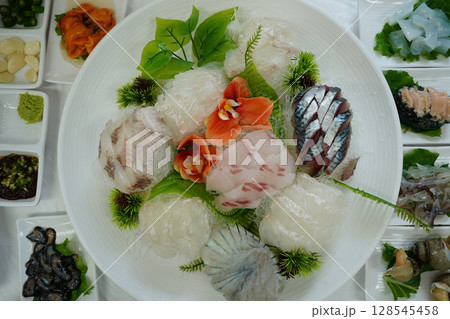 Assortment of Freshly Sliced Sashimi on White Plate 128545458