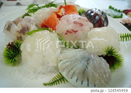 Assortment of Freshly Sliced Sashimi on White Plate Assortment of Freshly Sliced Sashimi on White Plate 128545459