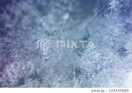 Macro snowflakes showing intricate winter details on dark background Macro snowflakes showing intricate winter details on dark background 128545689