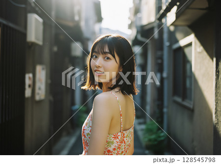 路地裏で微笑む女性の自然光ポートレート 128545798