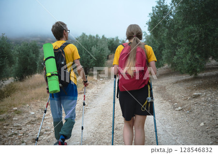 Young Couple Hiking on a Scenic Natural Trail with Backpacks 128546832