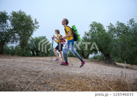 Young Couple Engaging in Hiking with Trekking Poles in Scenic Nature Young Couple Engaging in Hiking with Trekking Poles in Scenic Nature 128546835
