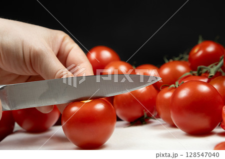 Cutting Mini Ripe Tomatoes on Cutting Board. Healthy Food Preparation. 128547040