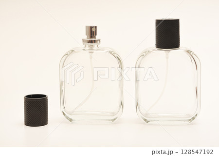 Empty glass perfume bottle. Elegant transparent flacon once filled with fragrance, now standing clean and minimalistic, ideal for cosmetics or beauty-related concepts. 128547192