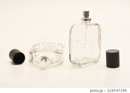 Empty glass perfume bottle. Elegant transparent flacon once filled with fragrance, now standing clean and minimalistic, ideal for cosmetics or beauty-related concepts. Empty glass perfume bottle. Elegant transparent flacon once filled with fragrance, now standing clean and minimalistic, ideal for cosmetics or beauty-related concepts. 128547194