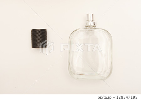 Empty glass perfume bottle. Elegant transparent flacon once filled with fragrance, now standing clean and minimalistic, ideal for cosmetics or beauty-related concepts. Empty glass perfume bottle. Elegant transparent flacon once filled with fragrance, now standing clean and minimalistic, ideal for cosmetics or beauty-related concepts. 128547195