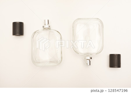 Empty glass perfume bottle. Elegant transparent flacon once filled with fragrance, now standing clean and minimalistic, ideal for cosmetics or beauty-related concepts. Empty glass perfume bottle. Elegant transparent flacon once filled with fragrance, now standing clean and minimalistic, ideal for cosmetics or beauty-related concepts. 128547196