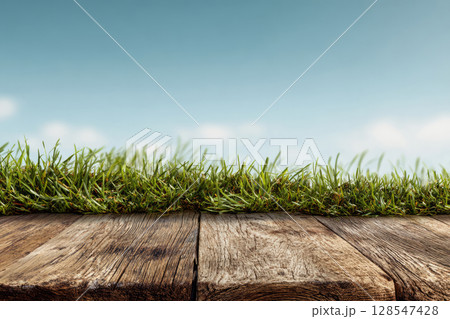 Grass and wooden table with blue sky in background 128547428