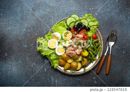 Nicoise salad with tuna, olives, green beans, tomatoes and quail eggs on a bed of lettuce with copy space Nicoise salad with tuna, olives, green beans, tomatoes and quail eggs on a bed of lettuce with copy space 128547819