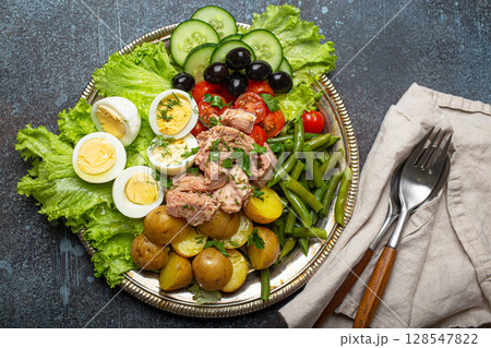 Nicoise salad with tuna, olives, green beans, tomatoes and quail eggs on a bed of lettuce Nicoise salad with tuna, olives, green beans, tomatoes and quail eggs on a bed of lettuce 128547822