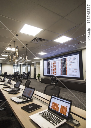 The laptops are open and the presentation is being shown on the large screen 128548327