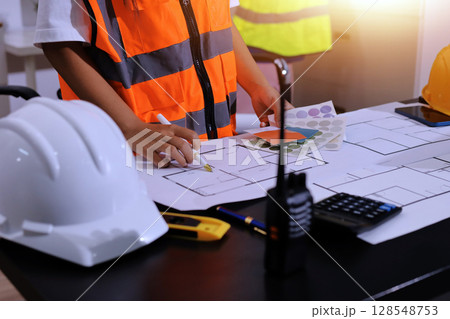 Closeup of team of industrial engineers meeting analyze machinery blueprints consult project on table in manufacturing factory. Working in manufacturing plant or production plant. 128548753