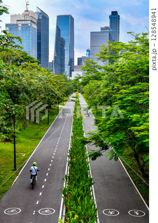 High angle view of the cycling and jogging paths in Benjakitti Park at evening, Bangkok, Thailand. High angle view of the cycling and jogging paths in Benjakitti Park at evening, Bangkok, Thailand. 128548941