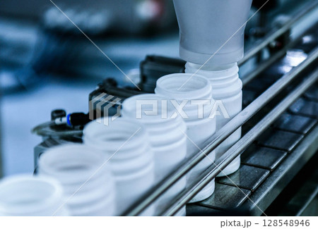 Close up counting and automatic tablet bottling machine in the pharmaceutical industry production line 128548946