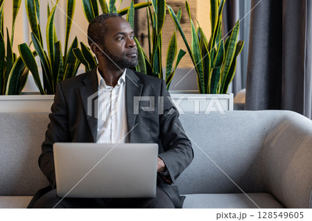 Businessman working on a laptop and looking busy and thoughtful Businessman working on a laptop and looking busy and thoughtful 128549605