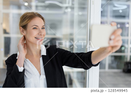 Blonde pretty business woman having a video call and smiling Blonde pretty business woman having a video call and smiling 128549945