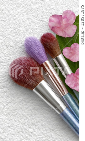 Flat lay of makeup brush set and beauty products on white canvas texture background with powder, top-down mock-up template for professional studio banner with space for text 128551975