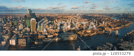 The image captures London's skyline with Tower Bridge, the Walkie Talkie, and the Shard. The River Thames and boats add to the city's vibrant scene. The image captures London's skyline with Tower Bridge, the Walkie Talkie, and the Shard. The River Thames and boats add to the city's vibrant scene. 128553279