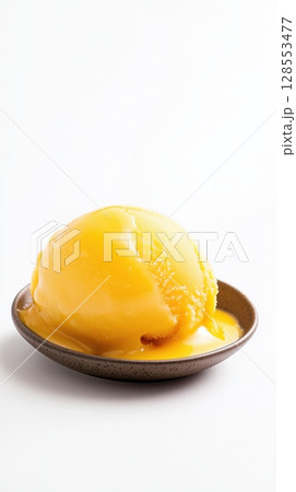 Mango sorbet scoop on a minimal matte plate, isolated on white with bright yellow color and glossy tropical texture, styled for packaging or ads. 128553477