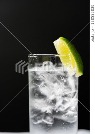 【カクテル素材】氷の入ったグラスに注がれた美味しそうなジントニック・黒バック【ドリンク素材】 128553839
