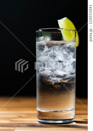 【カクテル素材】氷の入ったグラスに注がれた美味しそうなジントニック・黒バック【ドリンク素材】 128553841
