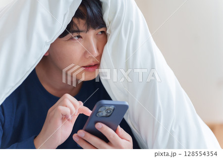 ベッドで落ち込む男性 ベッドで落ち込む男性 128554354