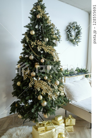 The Christmas tree is beautifully decorated in the living room The Christmas tree is beautifully decorated in the living room 128555691