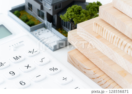 電卓と木材とミニチュアの一戸建て住宅 128556871