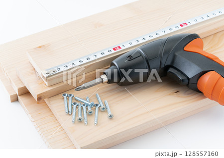 DIYイメージのタッピングねじと木材と電動ドライバーと巻き尺 DIYイメージのタッピングねじと木材と電動ドライバーと巻き尺 128557160