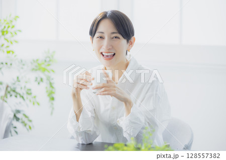 リビングでコーヒーを飲むミドルの女性 128557382