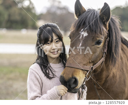 模様のある馬と寄り添う女性、穏やかで優しいふれあいの時間 128557920