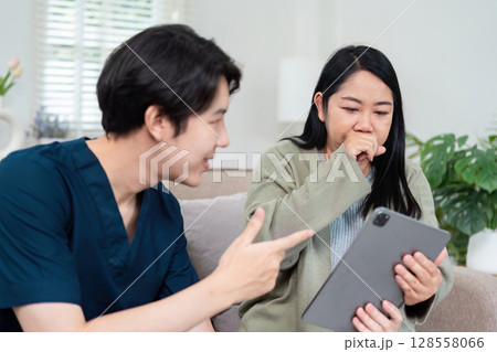 Healthcare Professional Consulting Patient Using Digital Tablet in Modern Clinic Setting 128558066