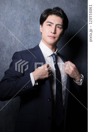 襟を整えて準備をするスーツを着たビジネスマン 襟を整えて準備をするスーツを着たビジネスマン 128558861