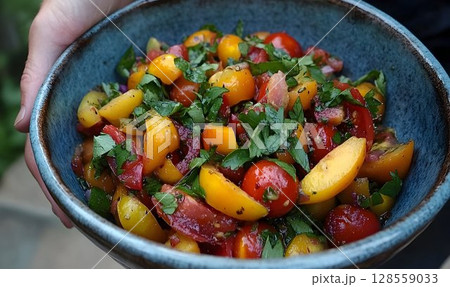 Vibrant summer tomato salad in rustic bowl colorful food photography 128559033