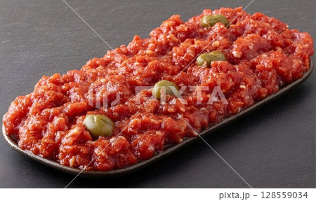 Finely textured reddish food dish with olives culinary image 128559034