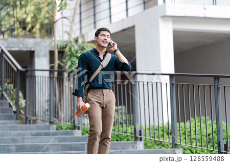 Young Man Embracing Eco Life with Reusable Water Bottle and Sustainable Fashion in Urban Setting Young Man Embracing Eco Life with Reusable Water Bottle and Sustainable Fashion in Urban Setting 128559488