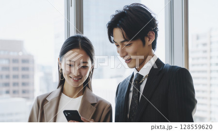 スマホでスケジュール確認する若手社員 128559620