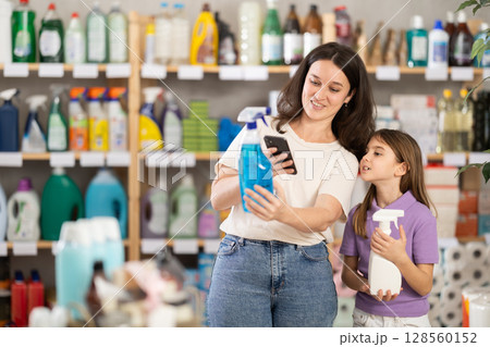 Woman with daughter scanning qr code for spray 128560152