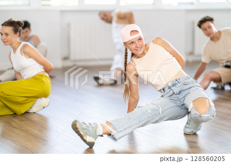 Teenage girl practicing hip-hop floor-works in training hall Teenage girl practicing hip-hop floor-works in training hall 128560205