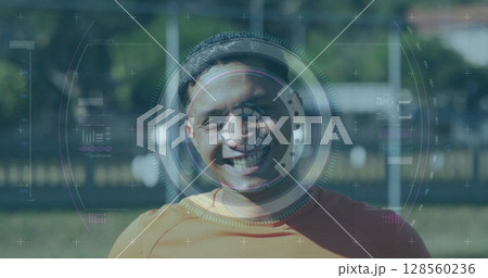 Scope scanning over digital interface with data processing against male soccer player smiling 128560236