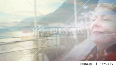 Image of glowing light over portrait of happy senior woman Image of glowing light over portrait of happy senior woman 128560315