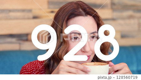 Image of numbers changing over woman drinking coffee Image of numbers changing over woman drinking coffee 128560719