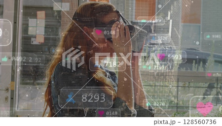 Image of social media icons over globe and woman using vr headset 128560736
