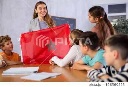 Teacher showing Morocco flag to group of schoolchildren 128560823